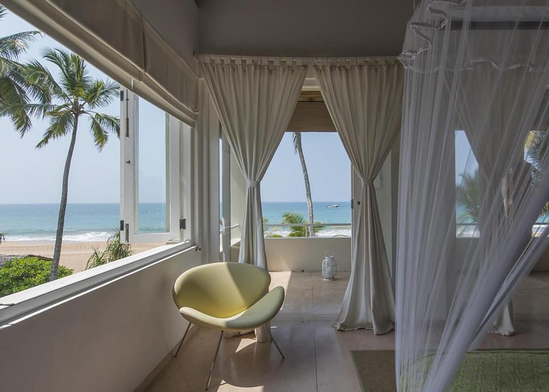 King suite sitting area with lounge chair and direct ocean view in Induruwa