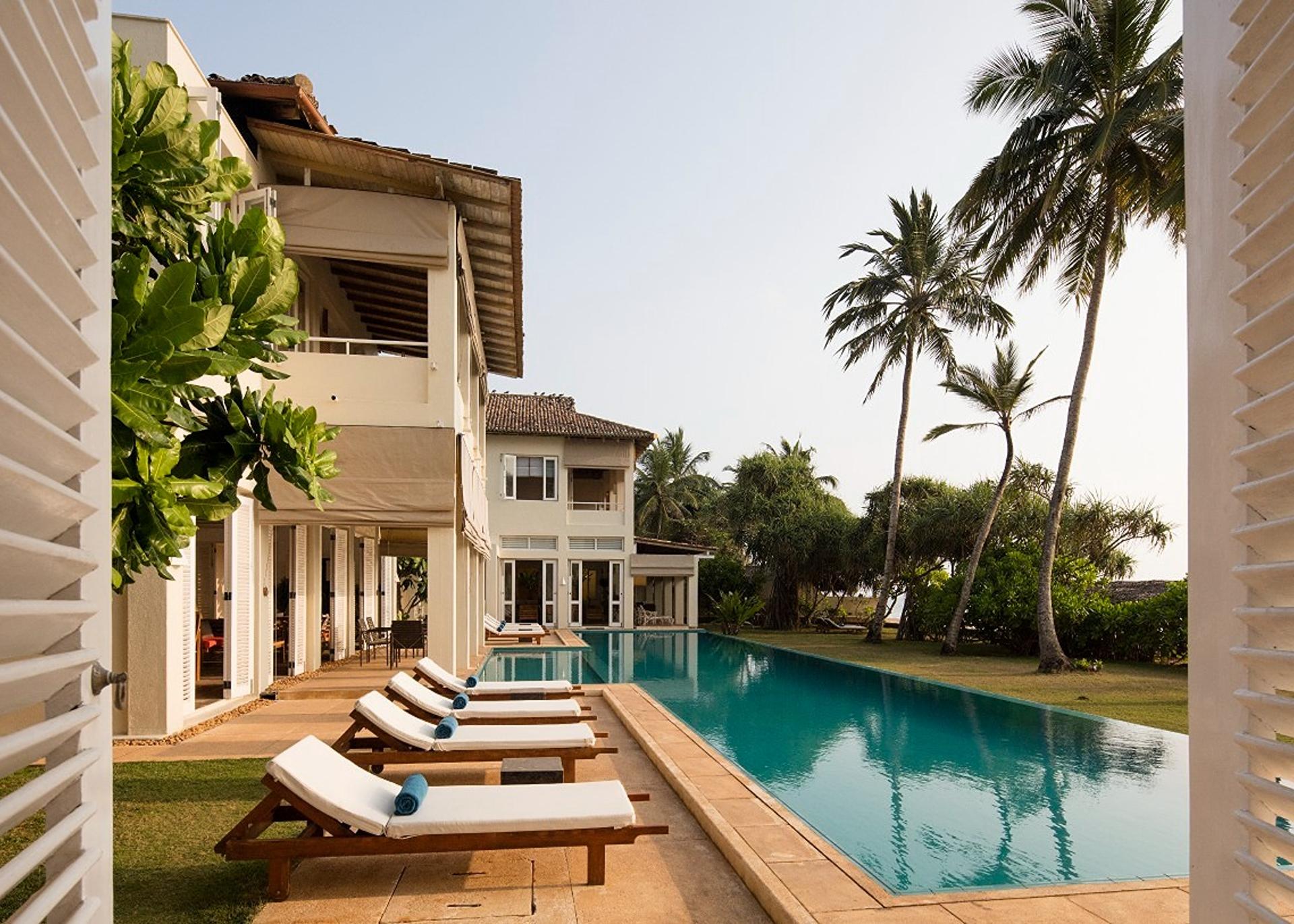 Sagara wing king suite with curtained ocean view windows and relaxed coastal decor