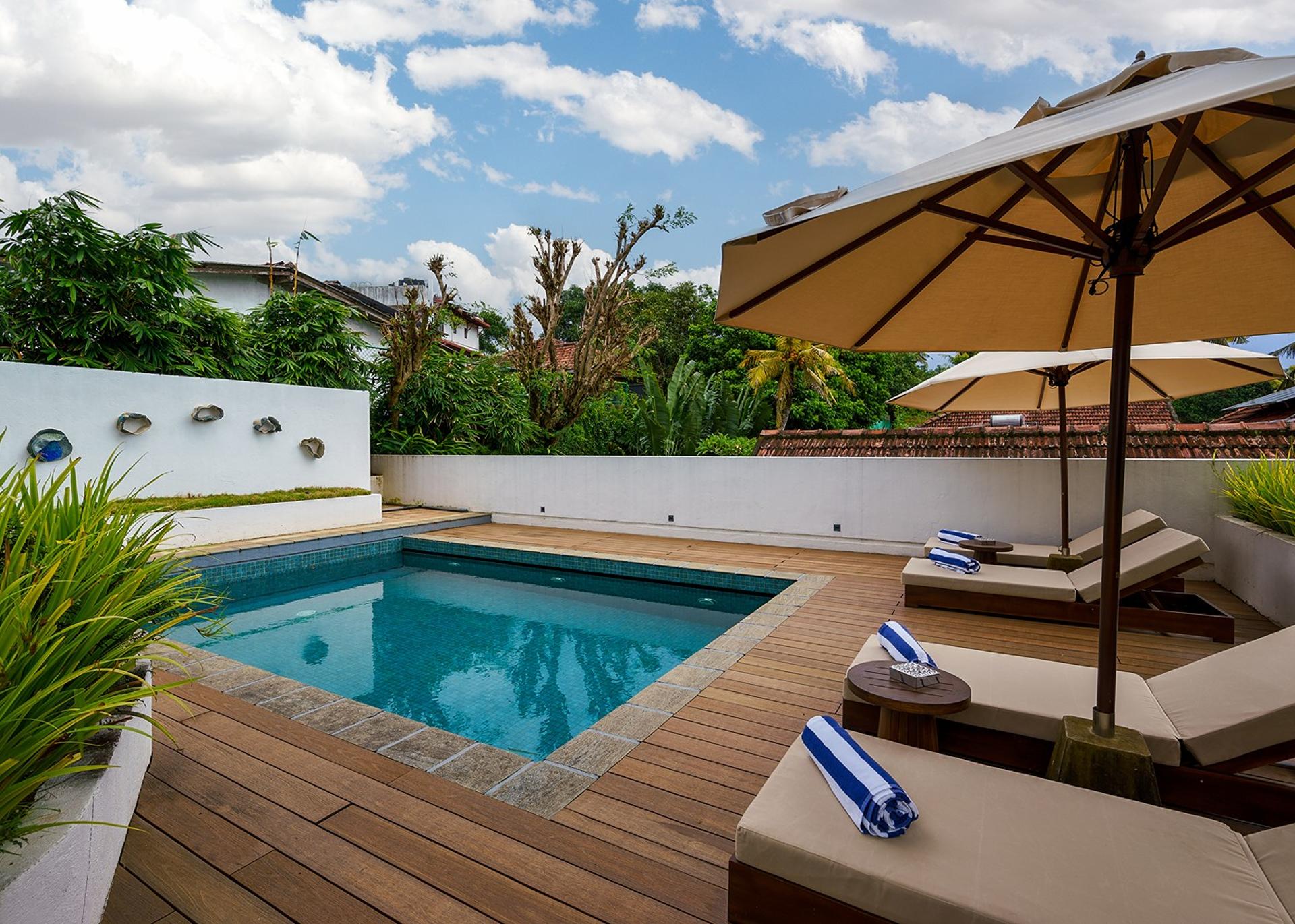 Elliot House Galle pool deck with timber sun loungers and tropical garden