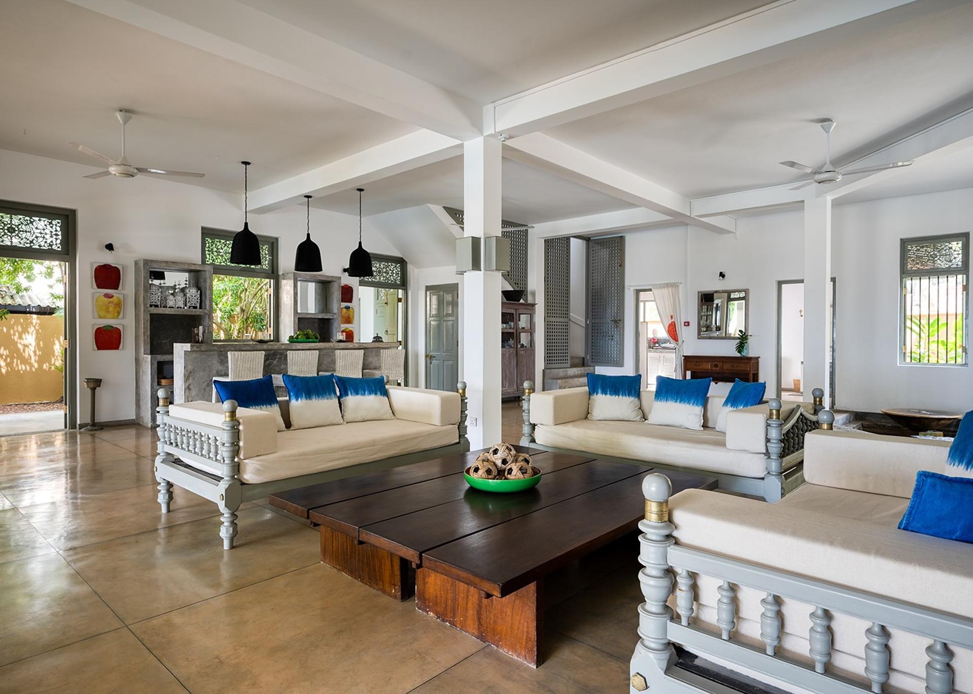 Beachfront villa wide open plan living room with artwork and blue accents