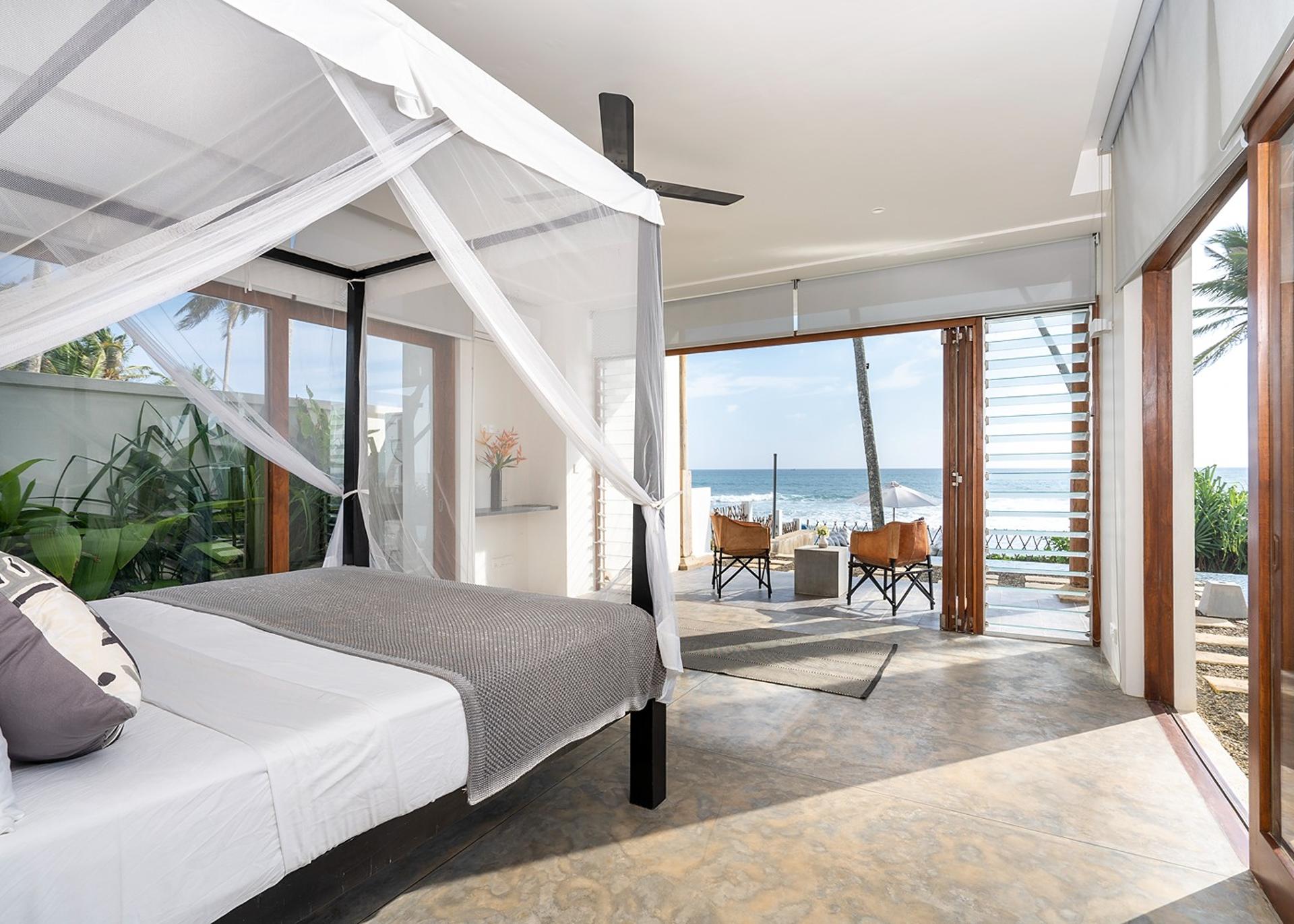 Talpe beachfront villa bedroom with canopy bed and timber window frame