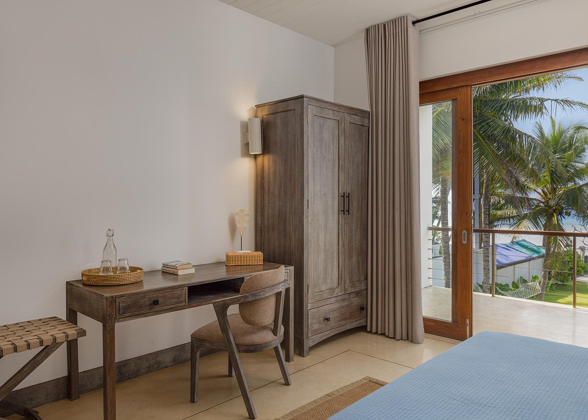 Ahangama beachfront villa bedroom with ocean view, desk and palm trees