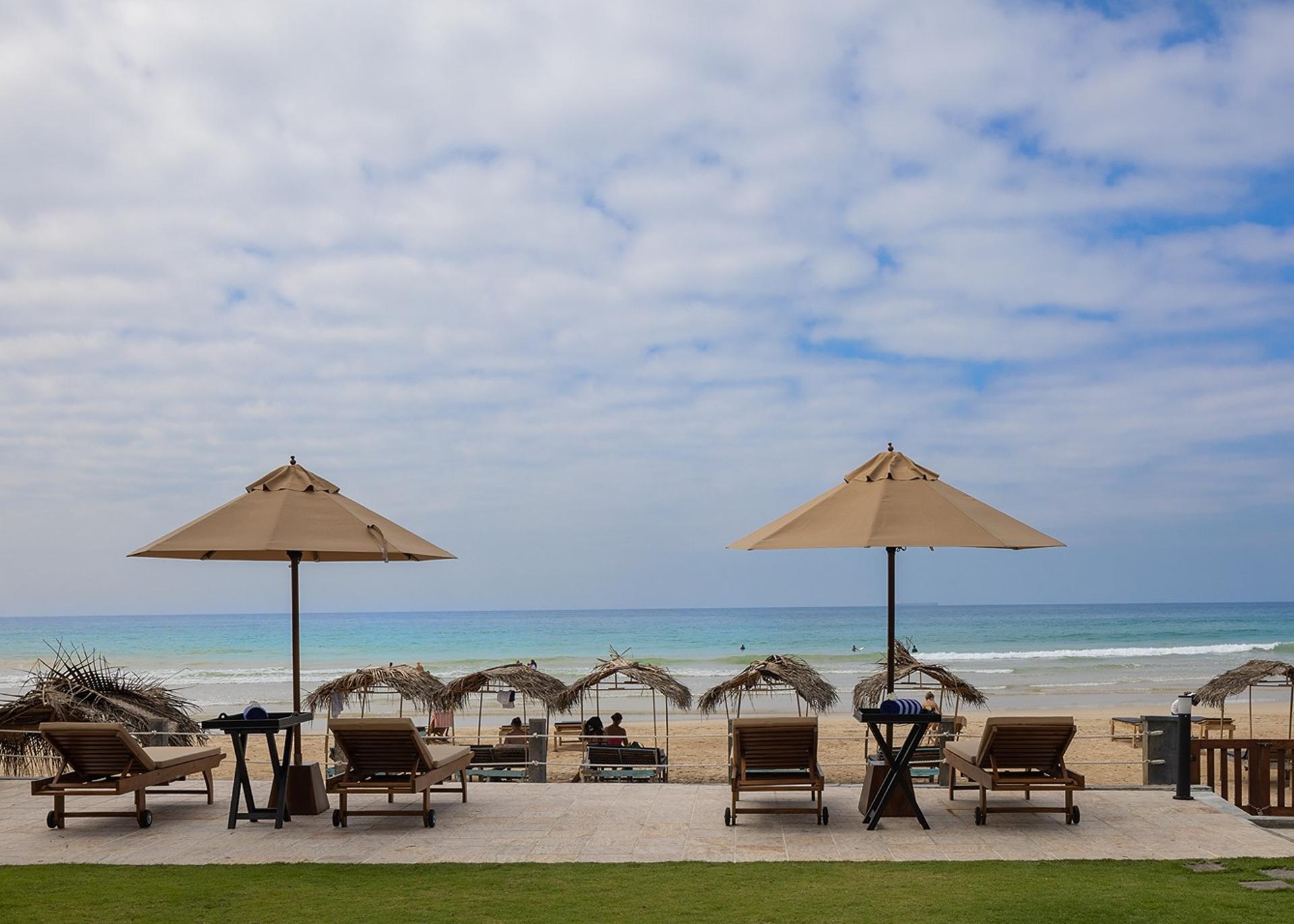 Ahangama beachfront villa pool with sun loungers and umbrellas leading to beach