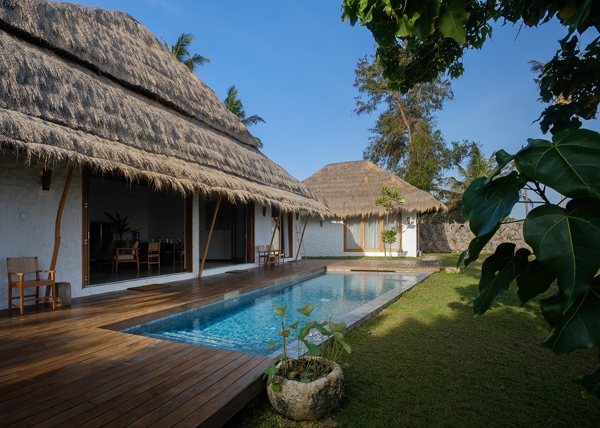 Boho House Mirissa pool with thatched villa facade and ocean view