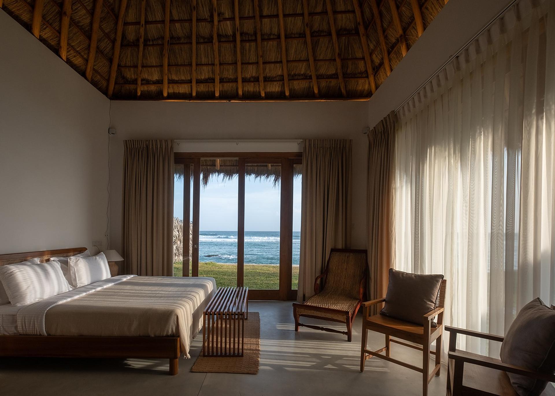 Mirissa villa master bedroom with wide ocean view and thatched ceiling