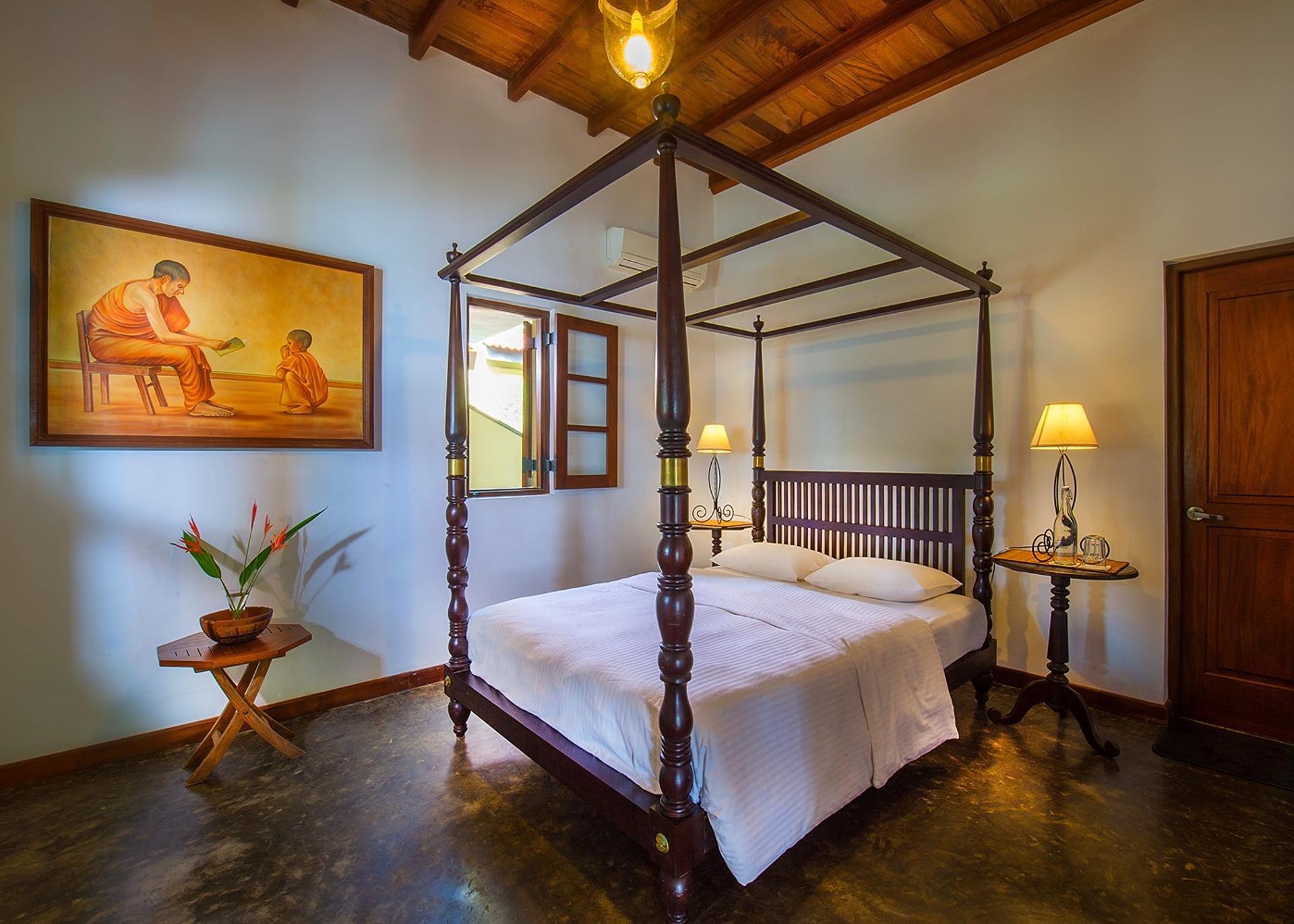 Matara villa poolside room full view of four-poster bed with artwork