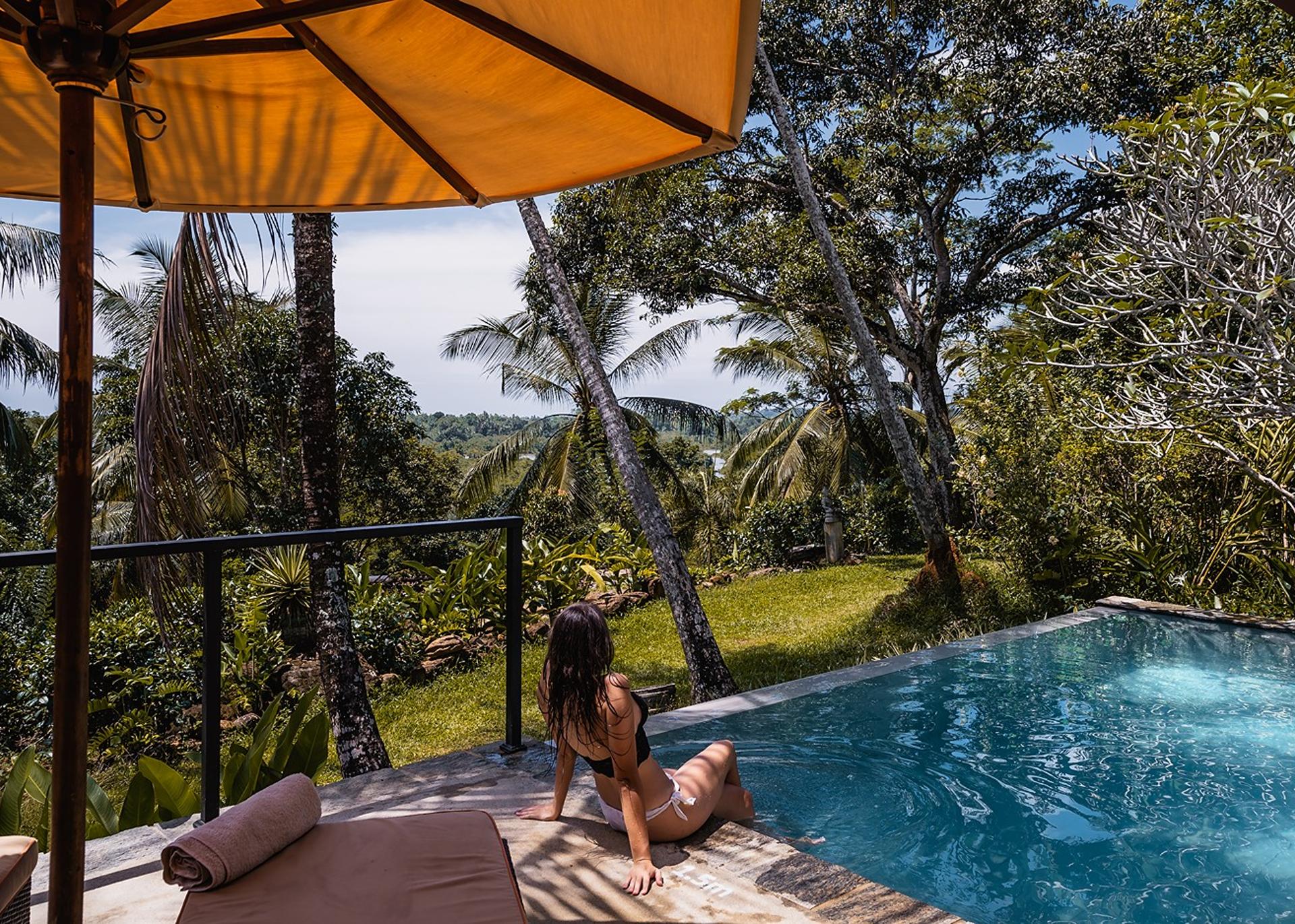 Pool daybed with canopy and tropical garden setting