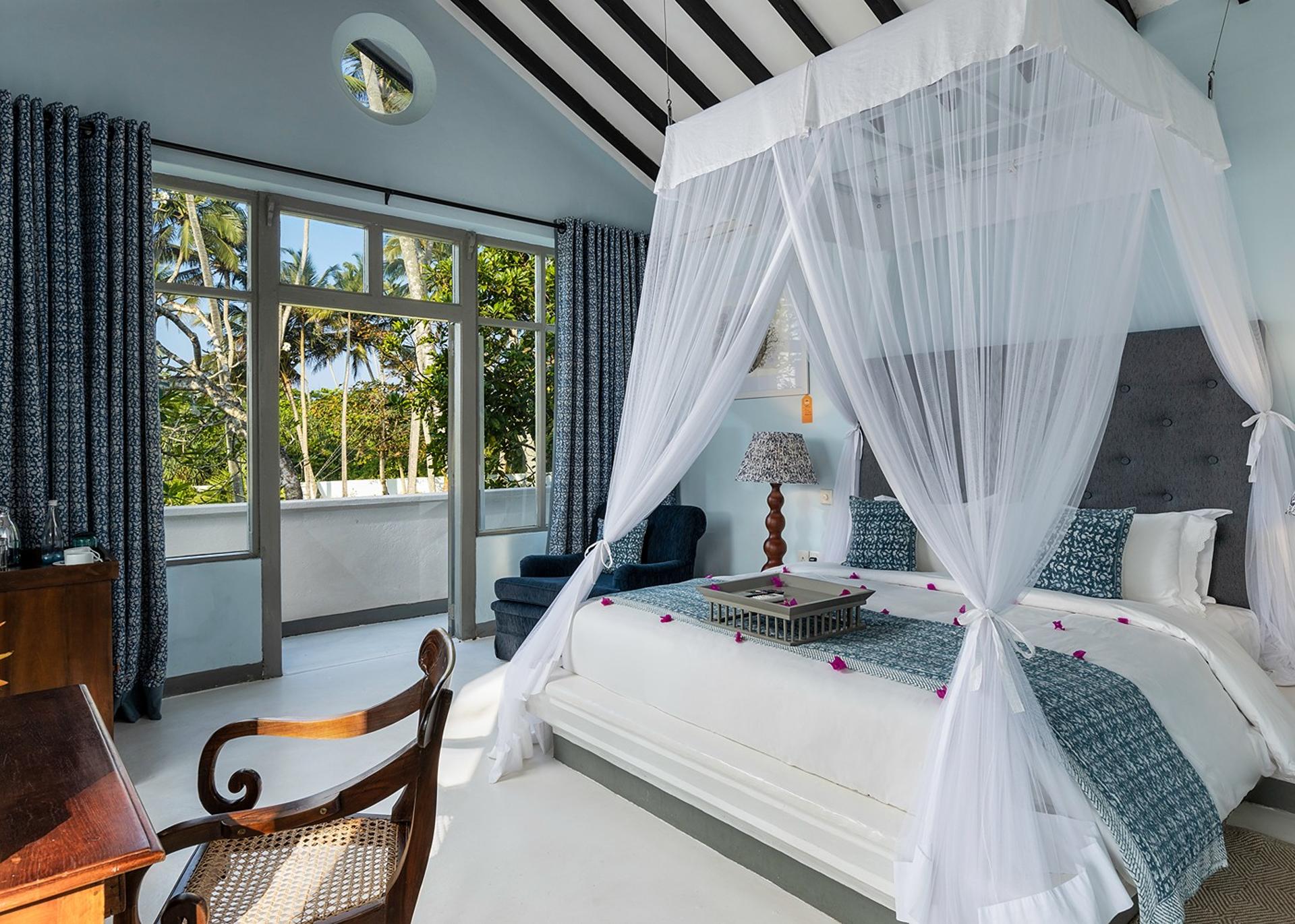 White canopy bedroom with blue ocean-inspired accents at Heritage House Bentota, Sri Lanka