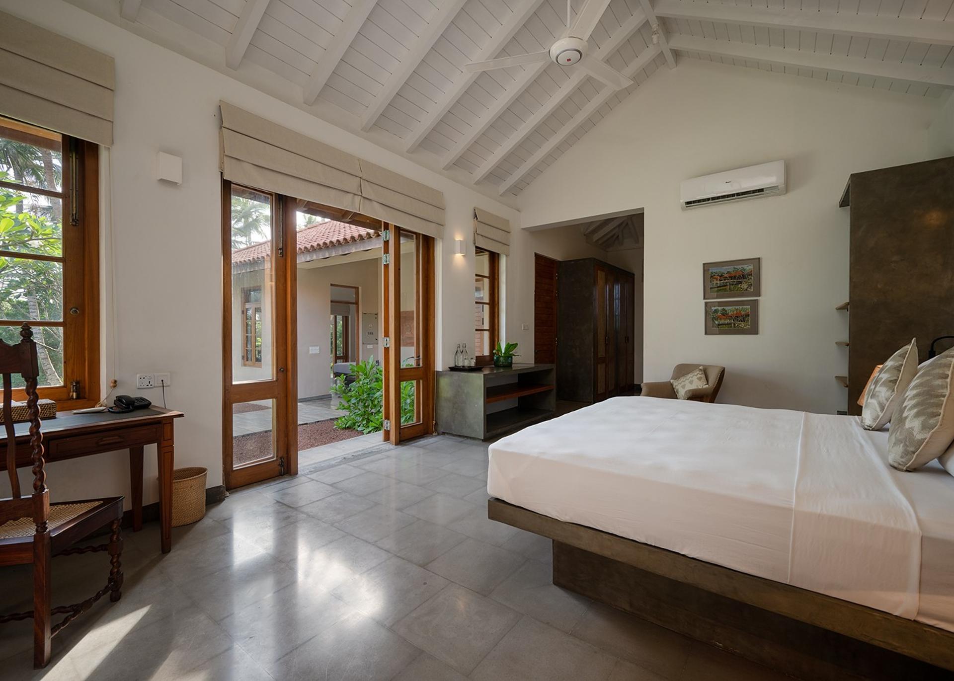 King bedroom with doors fully open to tropical garden at Kirana Villa, Bentota