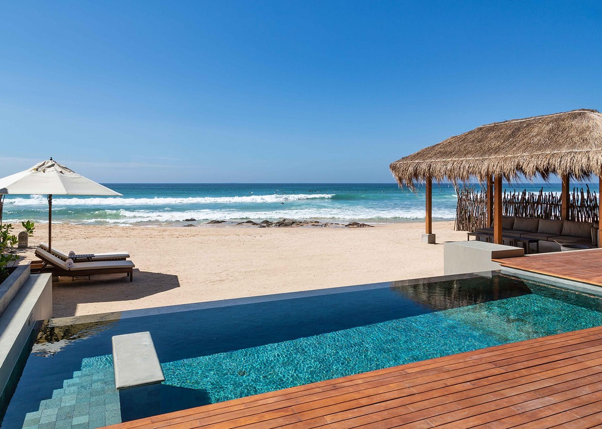 Wide daytime view of The Six Weligama pool with pavilion and beach, Midigama, Sri Lanka