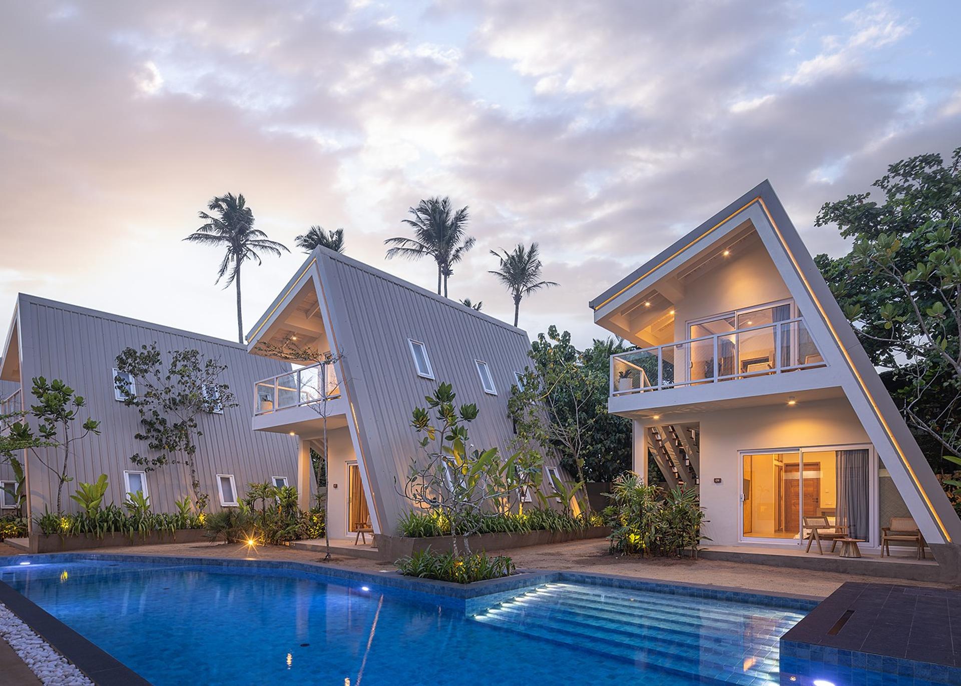 Asaya Sands Mirissa pool and A-frame chalets at dusk with palms, Mirissa, Sri Lanka