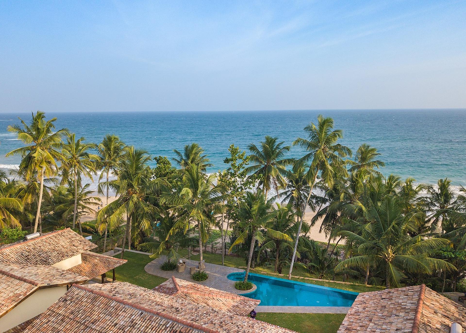 Aerial of Abiman Dickwella villa and pool from front with beach, Dickwella, Sri Lanka