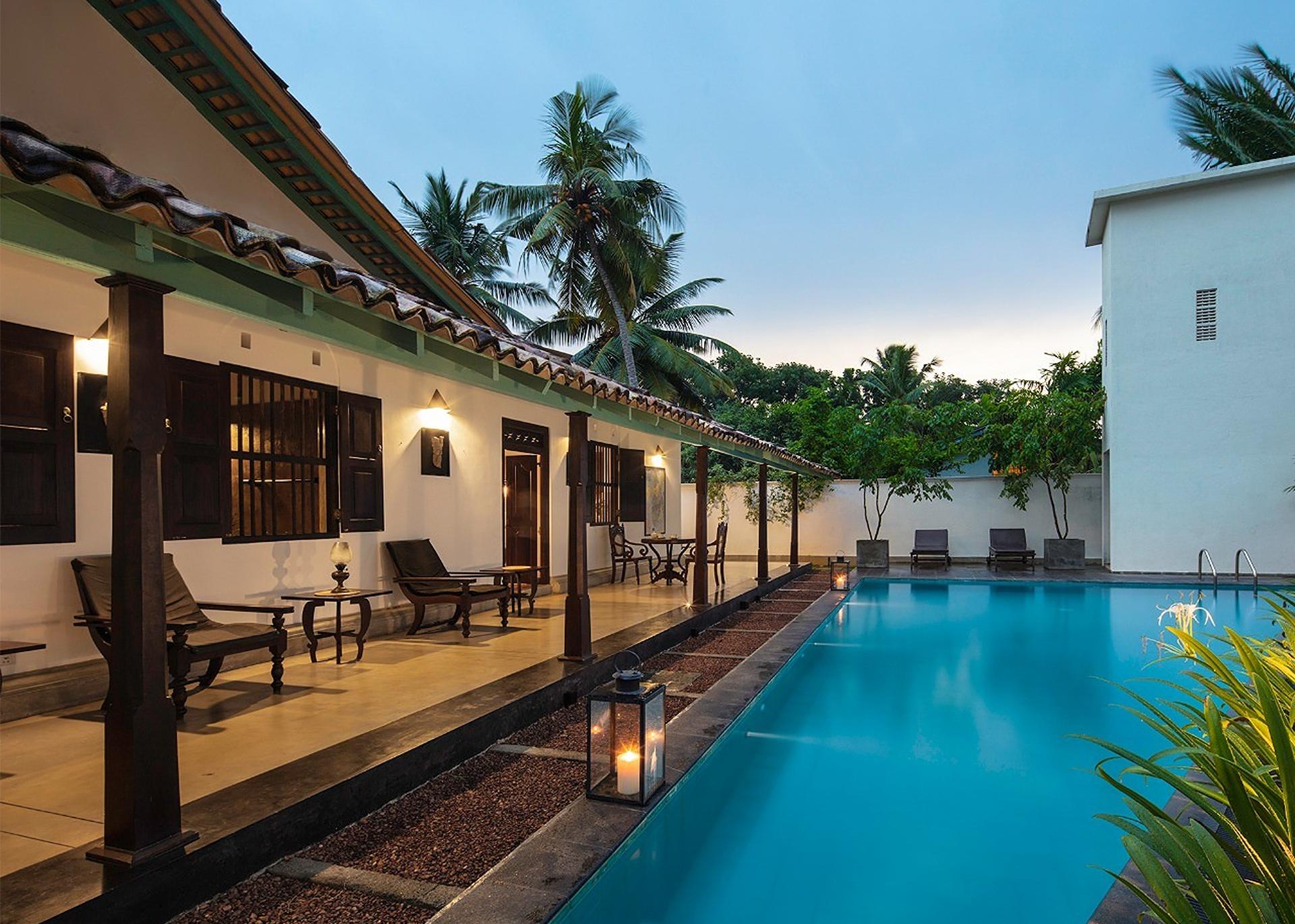 Pool with colonnade at dusk, Magalla Casa Galle