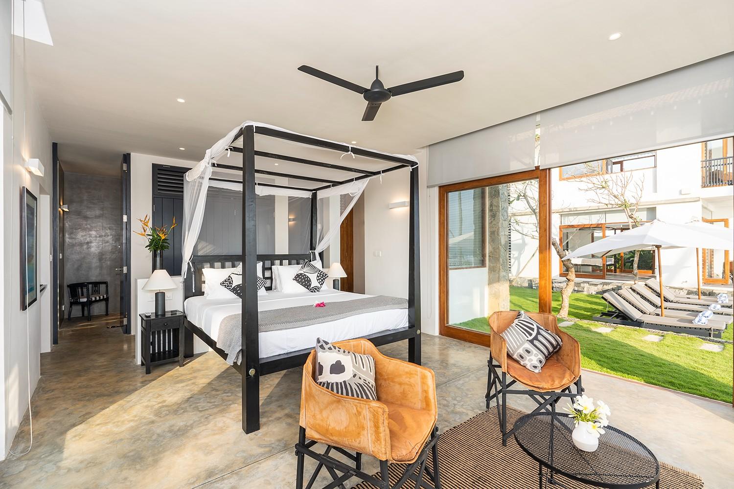 Talpe beachfront villa bedroom with four-poster bed and balcony ocean view