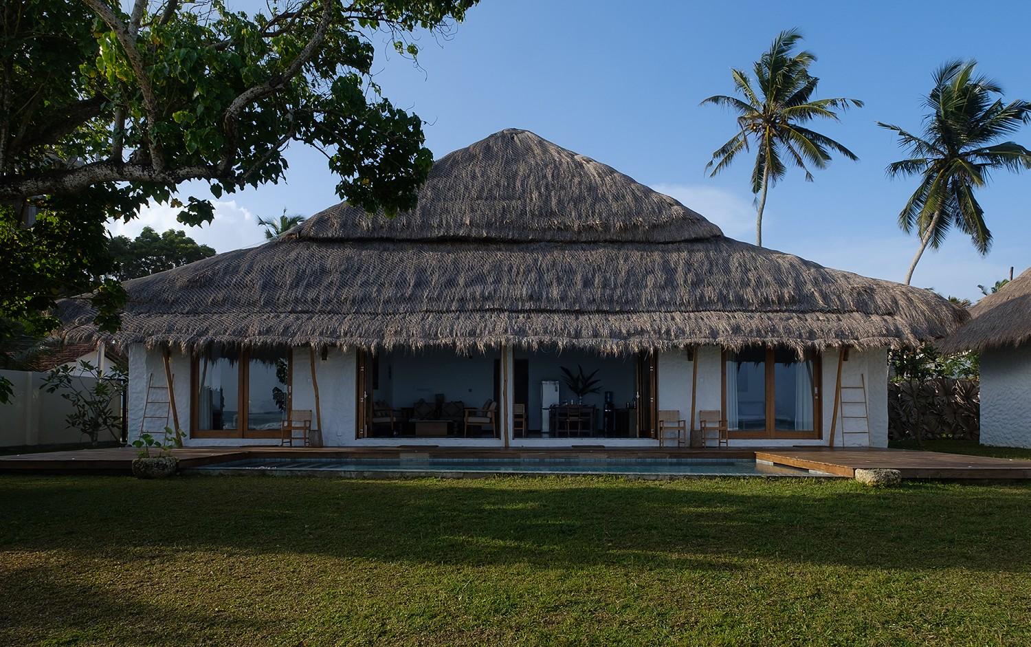 Boho House Mirissa exterior with thatched roof and tropical garden daytime