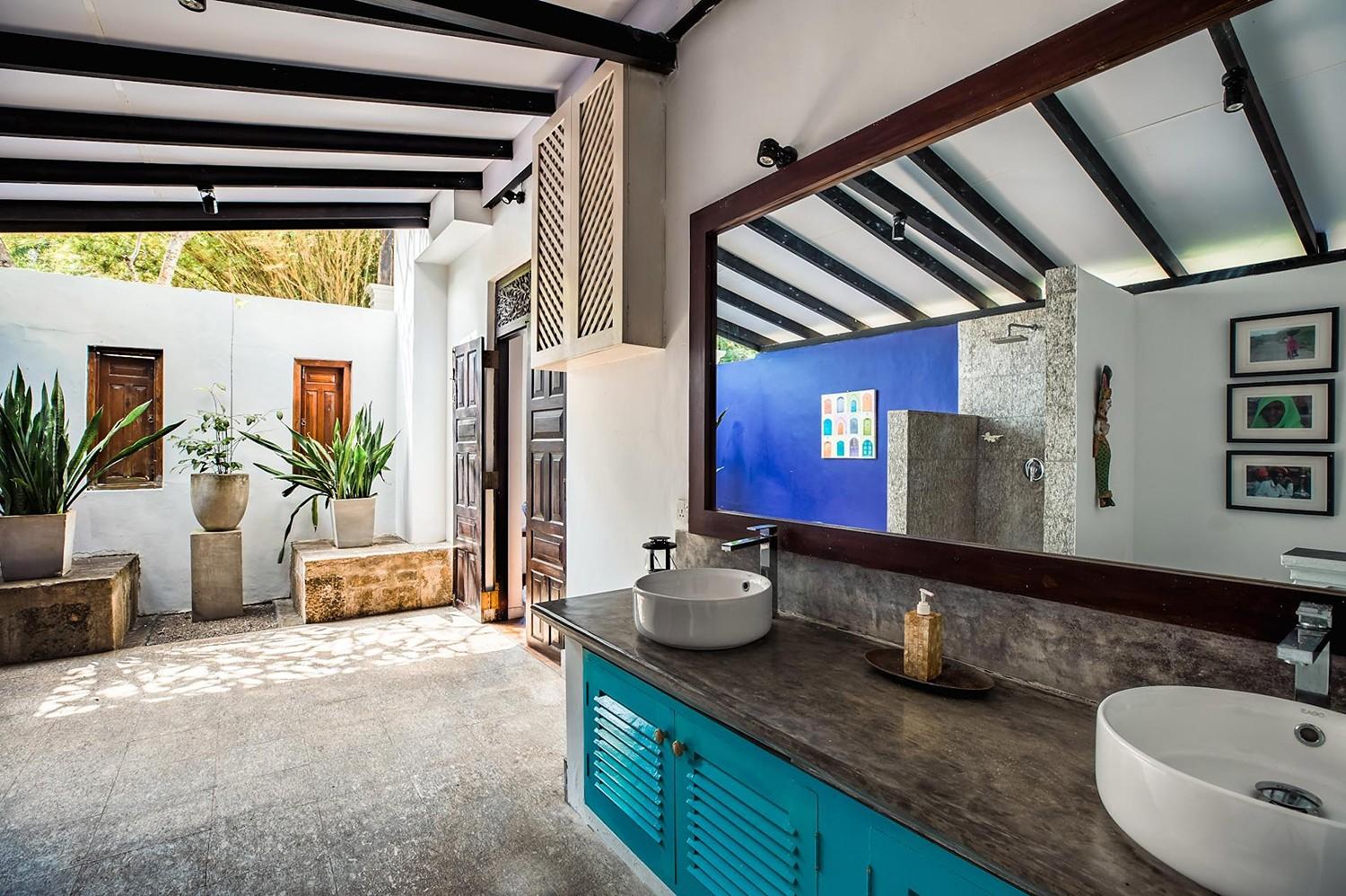 Outdoor bathroom with blue mosaic tiles, open-air shower and tropical garden at Casa Lago, Koggala